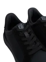 Championes urbanos Marruecos de color negro, confeccionados en ecocuero con detalles de paneles en ecogamuza en los laterales, pas cordones y talón. Poseen suela de goma al tono.
