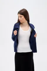 Cardigan de punto con diseño de ochos, color azul marino, con cuello solapa, cierre frontal con botones y mangas largas con puños acanalados.