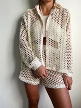 Camisa de playa color crema, de tejido crochet con botones frontales y cuello clásico.