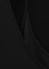 Vestido largo negro de manga larga, con escote redondo y diseño ajustado que se ensancha levemente hacia el suelo.