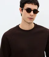 Buzo masculino de textura waffle, con cuello redondo y mangas largas. Confeccionado en una mezcla de algodón y poliéster, presenta un diseño cerrado y minimalista.