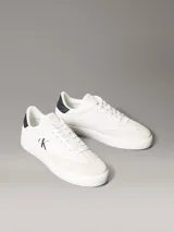 Zapatillas de ante Calvin Klein de color blanco, con detalles en contraste negro en el talón e inserciones de ante en la puntera. Cuentan con cordones blancos, suela de goma y el monograma de la marca en el lateral y la lengüeta.