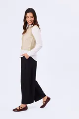 Pantalón barrel negro de corte ancho y relajado, confeccionado en poliéster con bolsillos laterales y cintura de tiro medio.