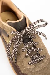 Zapatilla de cuero combinada en tonos marrones y visón, con diseño de paneles superpuestos, cordones jaspeados y suela de goma color caramelo.