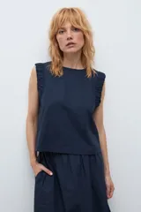 Blusa sin mangas color rojo, con cuello redondo y detalle de drapeado en los hombros. Presenta un corte recto y holgado.
