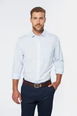 Camisa de vestir blanca de manga larga, con cuello clásico y cierre frontal de botones.