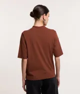 Blusa básica de algodón color celeste, con cuello alto y mangas cortas holgadas.
