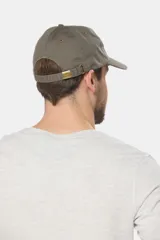 Gorro con visera de lona color verde oliva con parche circular de goma negro en el frente.