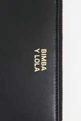 Billetera de estructura rígida Bimba y Lola, color naranja, con cierre de cremallera y tirador de cordón. Presenta el logo de la marca grabado en dorado en el frente.