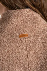 Tapado de poliéster con textura en color beige, de calce al cuerpo. Cuenta con cuello alto, cierre frontal de botones oscuros y bolsillos laterales.