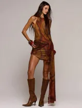 Vestido corto de microtul con diseño de doble capa y estampado abstracto en tonos marrones. Presenta escote halter y un detalle de frunce lateral con una tira larga colgante.