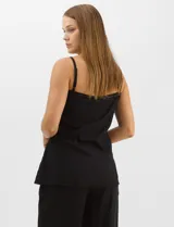 Conjunto monocromático compuesto por un top de breteles finos con escote recto y cierre frontal de botones, y un pantalón de tiro alto con pierna amplia y bolsillos laterales.
