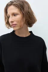 Sweater de punto color ciruela, con cuello redondo, mangas 3/4 y corte holgado.