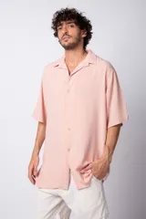 Camisa de manga corta con cuello cubano, confeccionada en fibrana premium. Presenta un corte oversize y cierre frontal con botones al tono.