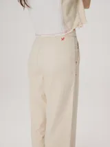 Pantalón tipo bombacha de campo color beige, de corte holgado con pinzas en la cintura y puños ajustados en los tobillos. Presenta costuras a contratono y bolsillos laterales.