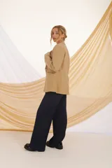 Blazer negro de corte clásico con solapas y cierre frontal con un botón dorado.