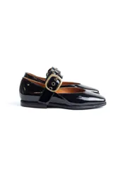 Zapatos tipo Mary Jane de charol negro con punta cuadrada y tira con hebilla metálica dorada sobre el empeine. Interior forrado en cuero color suela.