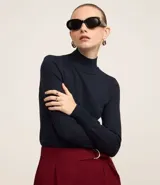 Blusa de manga larga confeccionada en viscosa sostenible, color azul marino, con cuello alto.