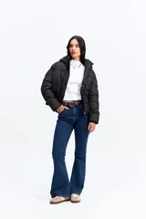 Campera puffer negra con capucha, diseño corto y acolchado, cierre frontal con botones a presión y puños ajustados.