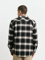 Sobrecamisa de manga larga con diseño a cuadros, cuello camisero y bolsillo frontal. Confeccionada en tejido de poliéster y algodón, sin forro.