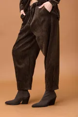 Pantalón baggy de corte holgado y silueta amplia, confeccionado en tela con textura aterciopelada. Presenta cintura elástica y bolsillos laterales.