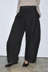Pantalón de tiro medio confeccionado en mezcla de algodón, con diseño de corte recto y holgado. Presenta cintura con trabillas, cierre frontal con cremallera y botón, y bolsillos laterales ocultos en las costuras.