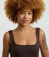 Vestido largo tipo midi de corte ajustado, confeccionado en poliamida con elastano. Presenta escote cuadrado, breteles anchos y una abertura lateral en el ruedo.