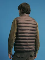 Chaleco acolchado de diseño capitoneado con cierre frontal al tono, cuello alto y ribetes en sisas y ruedo.