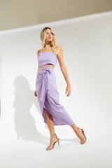 Pollera midi fucsia con corte irregular, abertura lateral y sistema de ajuste envolvente con lazo.