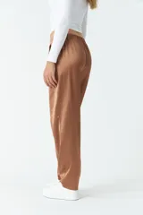 Pantalón de vestir color marrón satinado, de tiro medio, corte recto y con bolsillos laterales.