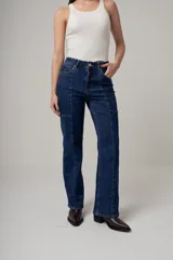 Jean de denim negro, tiro alto y corte recto, con costuras verticales decorativas en el frente.