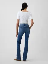 Jean de corte baby boot con tiro medio y lavado azul medio, confeccionado en denim con costuras reforzadas y cierre frontal con botón y cremallera.