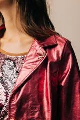 Blazer de cuero color celeste metalizado, con solapas, cierre con broches tipo tanca de madera y puños con detalle de piel sintética marrón.