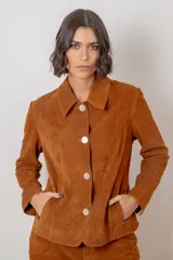 Blazer de gamuza color chocolate, con cuello camisero, cierre frontal de botones claros y corte recto.