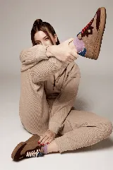 Zapatillas bajas de cuero color beige con detalles en marrón y azul. Cordones blancos y suela de goma color caramelo.