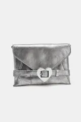 Bolso formato bandolera de material sintético con acabado metálico plateado. Presenta un diseño de solapa frontal con un cinturón decorativo que se cierra con una hebilla metálica en forma de corazón. Incluye un asa bandolera fina de cadena y un bolsillo interior con cierre.
