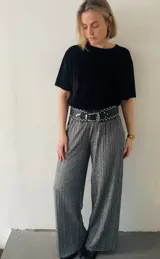 Blusa negra de terciopelo plisado con mangas cortas y cuello redondo.