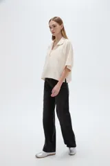Blusa de lino color natural, con cuello polo y escote en V, de mangas cortas holgadas y corte recto.
