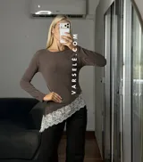 Blusa de manga larga color marrón, con corte asimétrico y detalle de puntilla blanca en el ruedo. Confeccionada en tejido de algodón y viscosa.