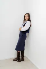 Falda midi de tiro alto confeccionada en pana color azul marino, con cierre frontal de botones y tajo delantero.