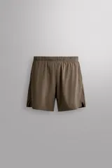 Short deportivo Zara Athleticz modelo Boulder 9", color beige, confeccionado en tejido técnico ligero y elástico. Cuenta con cintura elástica ajustable con cordón interior, bolsillos frontales y aberturas laterales en el bajo.