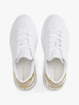 Zapatillas de plataforma Tommy Hilfiger, color blanco, con detalles metálicos dorados en el talón y monograma TH grabado en el lateral. Diseño de corte bajo con cierre de cordones.