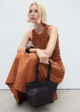 Vestido midi de diseño combinado con cuerpo entallado de textura arrugada y falda fluida. Presenta cuello perkins, diseño sin mangas y espalda abierta con cierre de botones.