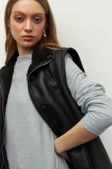 Remera gris de manga larga con cuello alto y corte diagonal en el ruedo.