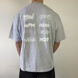 Remera gris melange de manga corta con corte boxy, cuello redondo y múltiples estampados en la espalda con variaciones del logotipo en color blanco.