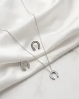 Set compuesto por collar y aros de acero italiano, con diseño de herradura adornado con circonias engastadas.
