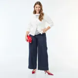 Pantalón de jean azul oscuro con corte wide leg, talle alto y costura vertical central en las piernas.