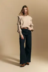 Sweater negro de manga larga, tejido suave y caída liviana, con volados en el delantero y mangas. Silueta recta.