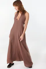 Vestido largo marrón de corte fluido y caída recta, con escote halter y tirantes anchos.