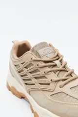 Zapatilla deportiva de estilo trekking con diseño técnico y urbano. Presenta una estructura combinada de paneles de malla y piezas de poliuretano, con sistema de cordones integrado y suela robusta con relieve para mayor estabilidad.